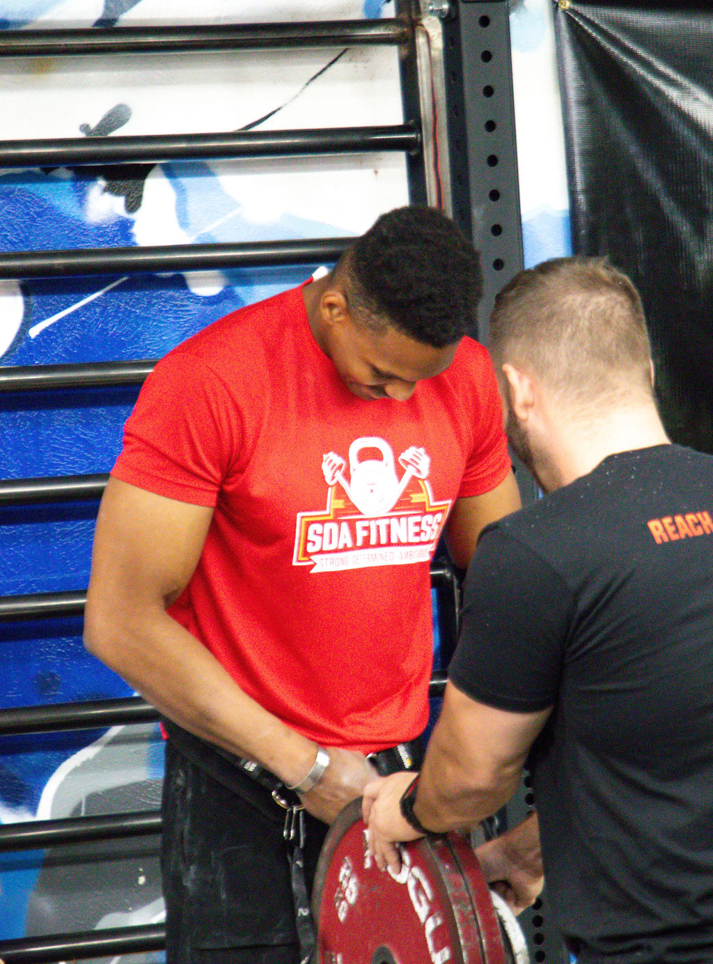 Coach Shai Ariola in the gym chalked up between heavy weighted calisthenics sets